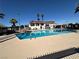 Inviting community swimming pool with clubhouse and palm trees under a sunny sky at 5720 Goldmount Ave, Las Vegas, NV 89107