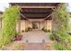 Elegant outdoor patio under a pergola with lush greenery and a wood walkway enhance the relaxing backyard space at 5741 N Park St, Las Vegas, NV 89149