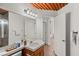 Well-lit bathroom with stone countertops, wood ceiling, and white cabinets at 59 Desert Dawn Ln, Henderson, NV 89074