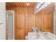 Bathroom with wood plank wall, tile shower, and pedestal sink at 59 Desert Dawn Ln, Henderson, NV 89074