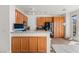 Open-concept kitchen with wood cabinets, tile floors, and modern appliances at 59 Desert Dawn Ln, Henderson, NV 89074