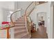 Elegant curved staircase with carpet steps and wooden banister at 59 Desert Dawn Ln, Henderson, NV 89074