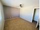 A spacious bedroom with neutral walls, a ceiling fan, and carpeted floor at 6245 Blushing Willow St, North Las Vegas, NV 89081