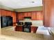 Well-equipped kitchen with rich wood cabinetry, granite countertops, and modern black appliances at 6245 Blushing Willow St, North Las Vegas, NV 89081