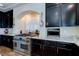 Spacious kitchen featuring granite countertops, stainless steel oven, dark wood cabinetry, and arched window at 6403 Brandon Hills Ct, Las Vegas, NV 89139