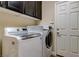 Laundry room featuring modern appliances, overhead cabinets, and a white door at 6403 Brandon Hills Ct, Las Vegas, NV 89139
