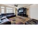 Spacious living room with a comfortable leather sectional sofa, a large entertainment center, and wood floors at 6403 Brandon Hills Ct, Las Vegas, NV 89139