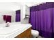 Bathroom featuring a single sink vanity, toilet and purple shower curtains at 6711 Quarterhorse Ln, Las Vegas, NV 89148