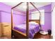 Bedroom with a four poster bed, purple walls, and hardwood flooring at 6711 Quarterhorse Ln, Las Vegas, NV 89148