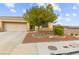Charming home featuring desert landscaping, mature shade tree, and attached two-car garage at 6711 Quarterhorse Ln, Las Vegas, NV 89148