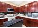 Well-equipped kitchen featuring dark wood cabinetry, stainless steel appliances, and white countertops at 6711 Quarterhorse Ln, Las Vegas, NV 89148