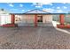 Gravel backyard features a covered patio, decorative brick columns and a single-story home at 704 Slayton Dr, Las Vegas, NV 89107