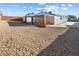 Spacious backyard featuring gravel landscaping, a covered patio, and decorative brick columns at 704 Slayton Dr, Las Vegas, NV 89107