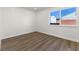An empty bedroom with white walls, wood floors, and a window that lets in natural light at 704 Slayton Dr, Las Vegas, NV 89107