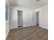 A minimalist bedroom with wood flooring, white walls, and a closet with sliding doors at 704 Slayton Dr, Las Vegas, NV 89107