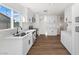 Bright kitchen featuring white cabinets, stainless steel appliances, and wood-look flooring at 704 Slayton Dr, Las Vegas, NV 89107