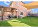 Expansive backyard featuring a covered patio, green turf, and recreational equipment at 744 Forest Peak St, Henderson, NV 89011