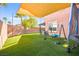 Backyard featuring green turf, mature palms, and a cozy swing set for outdoor entertainment at 744 Forest Peak St, Henderson, NV 89011