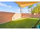 Beautiful backyard has a well-maintained green space, framed by a brick wall and mature trees at 744 Forest Peak St, Henderson, NV 89011