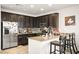 Kitchen featuring dark wood cabinetry, granite countertops, stainless steel appliances and bar stool seating at 744 Forest Peak St, Henderson, NV 89011