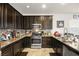 Updated kitchen with stainless steel appliances, granite countertops, and dark wood cabinetry at 744 Forest Peak St, Henderson, NV 89011