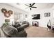 Bright living room featuring neutral-toned furniture, ceiling fan, and a wall-mounted TV at 744 Forest Peak St, Henderson, NV 89011