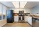 Well-lit kitchen showcasing stainless steel appliances, ample counter space and black refrigerator at 8070 W Russell Rd # 2015, Las Vegas, NV 89113