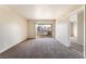 Spacious living room with neutral walls, plush carpeting and access to the outdoor balcony at 8070 W Russell Rd # 2015, Las Vegas, NV 89113
