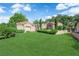 Expansive front lawn with manicured hedges and mature trees offering privacy and curb appeal at 8170 Round Hills Cir, Las Vegas, NV 89113