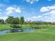 Picturesque view of the golf course, showcasing lush greenery, a serene pond, and mature trees on a sunny day at 8170 Round Hills Cir, Las Vegas, NV 89113