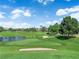 Scenic view of a golf course featuring sand traps, a lake, and lush green landscape at 8170 Round Hills Cir, Las Vegas, NV 89113