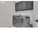 Functional laundry room with modern washer and dryer, and ample cabinet space at 8170 Round Hills Cir, Las Vegas, NV 89113