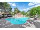 Community swimming pool surrounded by lush greenery, lounge chairs, and shade at 8170 Round Hills Cir, Las Vegas, NV 89113