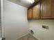 A small laundry room featuring tile floors, wood cabinets, and standard washer/dryer hookups at 8187 Deadwood Bend Ct, Las Vegas, NV 89178