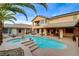 Stunning backyard showcasing a large pool, spa, covered patio, and meticulously maintained landscaping at 9475 Windham Heights Ct, Las Vegas, NV 89139