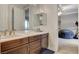 Bathroom with double sinks and vanity, offering ample counter space and storage, open to living space at 9475 Windham Heights Ct, Las Vegas, NV 89139
