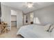 Well-lit bedroom with a bed dressed in white linens, featuring a desk and access to closet and bathroom at 9475 Windham Heights Ct, Las Vegas, NV 89139