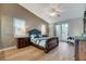 Serene bedroom with wood floors, a ceiling fan, and a sliding glass door leading to a private balcony at 9475 Windham Heights Ct, Las Vegas, NV 89139