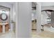 Hallway with decorative round mirror leads to a half bath and features arched architecture at 9475 Windham Heights Ct, Las Vegas, NV 89139