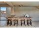 Outdoor kitchen with stone counter top and four stools at 9475 Windham Heights Ct, Las Vegas, NV 89139