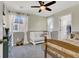 Charming bedroom featuring a white crib, large windows, and a ceiling fan at 4735 Agave Cactus St, North Las Vegas, NV 89031
