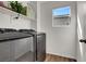 Modern laundry room with stainless steel front-loading washer and dryer at 4735 Agave Cactus St, North Las Vegas, NV 89031