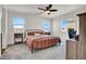 Spacious main bedroom featuring three windows, a ceiling fan, and neutral decor at 4735 Agave Cactus St, North Las Vegas, NV 89031