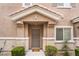 Charming front entrance featuring a neutral-toned door, manicured bushes, and a well-kept lawn at 10086 Aspen Rose St # 101, Las Vegas, NV 89183