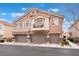 Inviting townhome with a private balcony and three-car garage spaces, complemented by manicured landscaping at 10086 Aspen Rose St # 101, Las Vegas, NV 89183