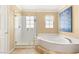 Bathroom featuring a tub, glass shower, and tile flooring at 10892 Royal Highlands St, Las Vegas, NV 89141