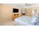 Bedroom with neutral colors, TV, ceiling fan, and plantation shutters at 10892 Royal Highlands St, Las Vegas, NV 89141