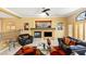 An inviting living room with fireplace, large windows, and a ceiling fan at 10892 Royal Highlands St, Las Vegas, NV 89141