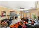 A cozy living room with a fireplace, ceiling fan, and comfortable seating at 10892 Royal Highlands St, Las Vegas, NV 89141