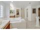 Elegant bathroom features a soaking tub, marble floors, glass shower door, and a vanity with ample counter space at 1465 Via Savona Dr, Henderson, NV 89052
